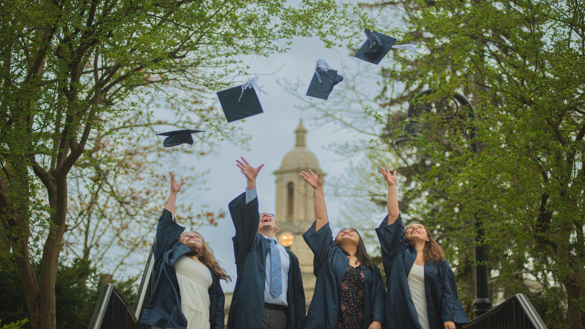 College graduates tossing graduation caps into the air
